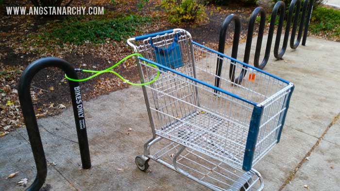 A shopping cart locked to a bike rack